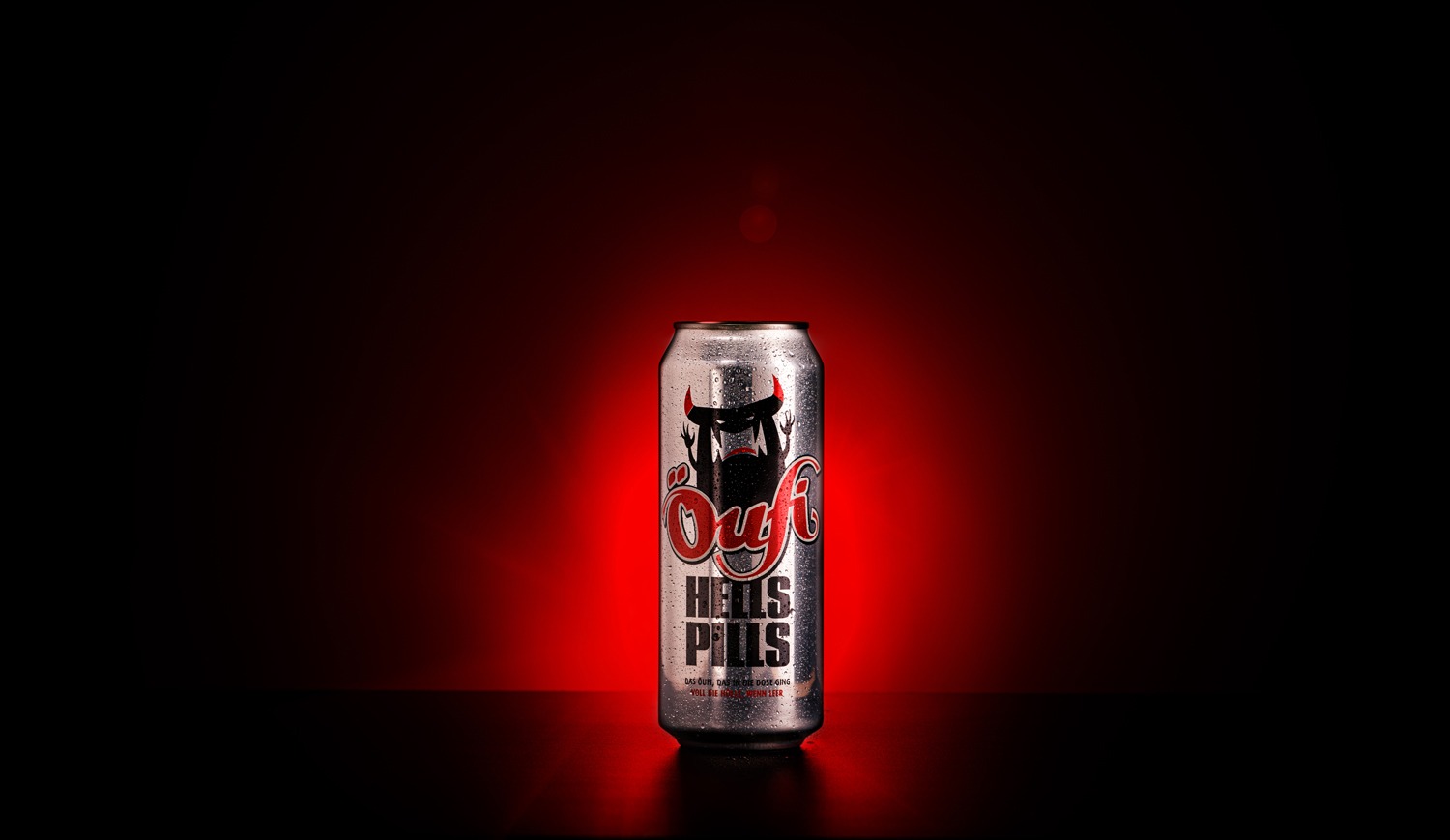 Silberne Getränkedose mit Teufelsmotiv vor rotem Hintergrund Silberne Getränkedose mit Teufelsmotiv, rote Hintergrundbeleuchtung